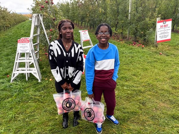 two students holding a bag of apples